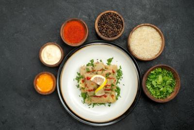 Close-Up View of Bowls with Spices and Sauces Surrounding Stuffed Cabbage – Free Download