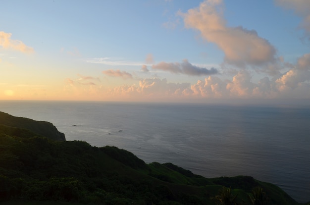 Calm Sea Surrounded by Hills and Greenery During Sunset – Free Stock Photo for Download