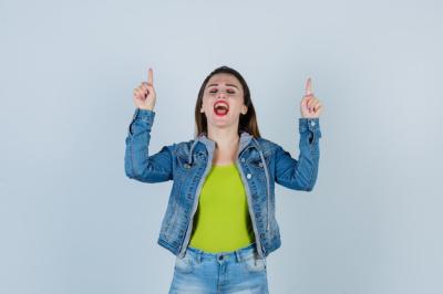 Beautiful Young Lady in Denim Outfit Pointing Up with Eyes Shut – Free Stock Photo, Download Free