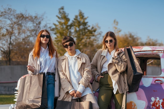 Young Happy Women with Shopping Bags by a Vintage Car – Free Stock Photo for Download