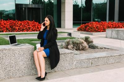 Businesswoman Talking on Cellphone Outside Office Building – Free Download