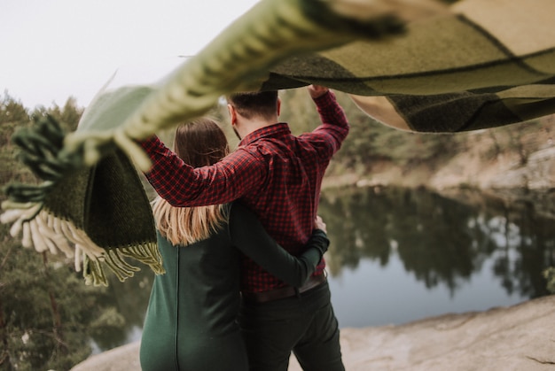 Loving Couple on the Shore of a Lake with Rug in the Wind – Free Download