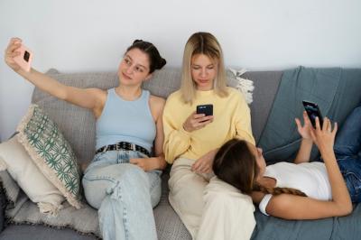 High Angle Shot of Girls on Couch with Smartphones – Free Download