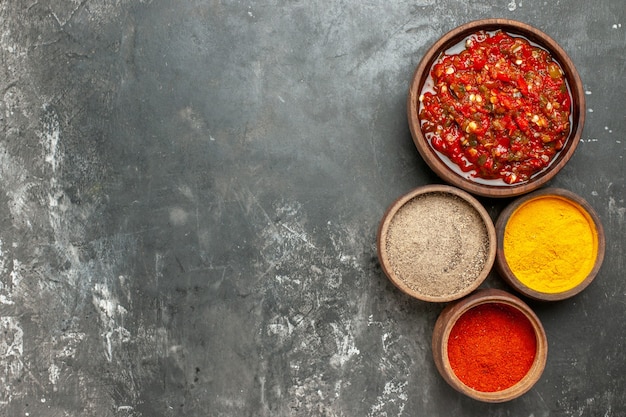 Top View of Adjika in Wooden Bowl Surrounded by Various Spices on Grey Background – Free Stock Photo for Download