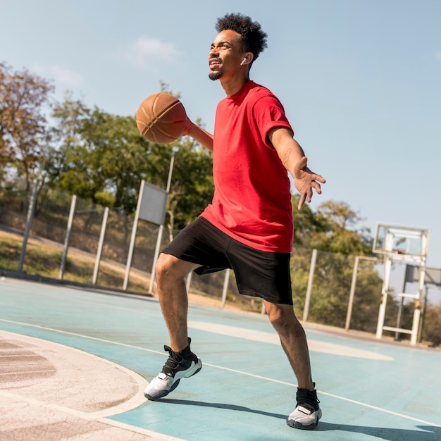 Dynamic Man Playing Basketball on a Field – Free to Download