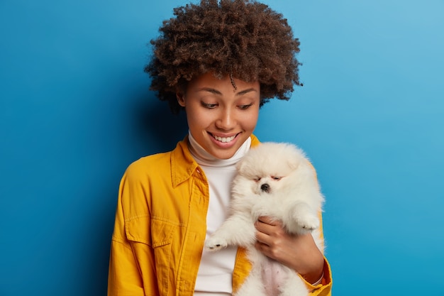 Caring Young Female Smiles at Her Sleeping Miniature Fluffy Dog – Free Stock Photo for Download