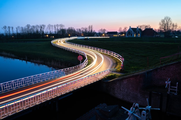 Stunning Nighttime Street Scene with Car Light Trails by the River – Free Download