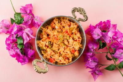 Delicious Meal in Pot Surrounded by Flowers on Pink Surface – Free Download