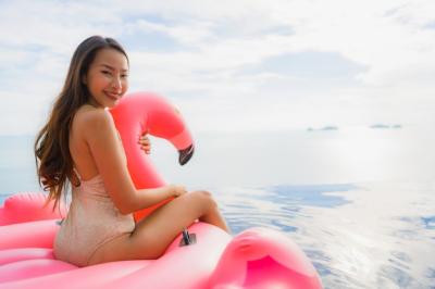 Portrait of a Young Asian Woman on an Inflatable Flamingo Float at a Hotel Resort Swimming Pool – Free Stock Photo for Download