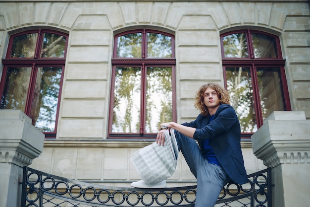 Reddish Young Man Reading Newspaper Near Classic Building – Free Stock Photo for Download