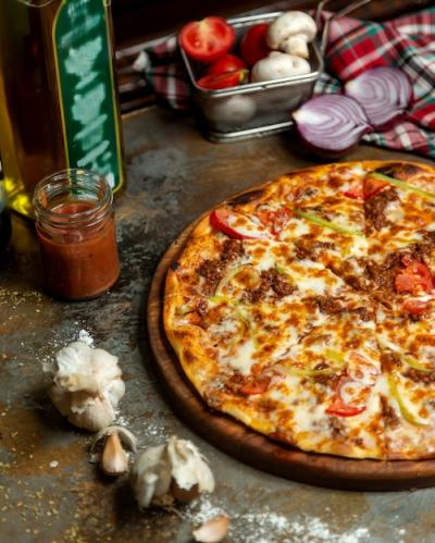 Delicious Half Meat Pizza Topped with Tomato, Bell Peppers, and Cheese – Free Download