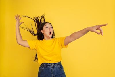 Young Black-Haired Woman in Yellow T-Shirt Against Yellow Wall – Free Download