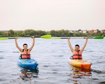 Enjoying Kayaking: Cheerful Men Holding Up a Kayak Oar – Free Stock Photo