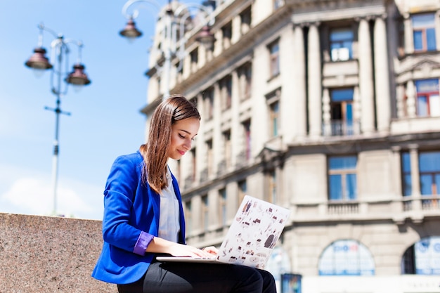 Woman Working on a Laptop in the Street – Free Stock Photo for Download