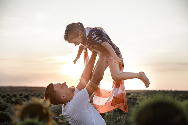 A Happy Family Celebrating with an American Flag at Sunset – Free Download