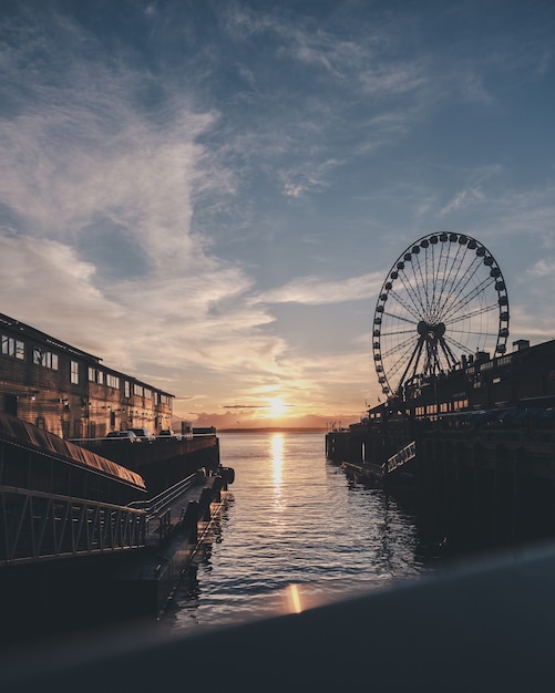 Vertical Shot of the Sea and Ferris Wheel Under a Blue Sky – Free Download