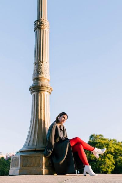 An Attractive Young Woman Sitting Under a Pillar with Crossed Legs – Free Download