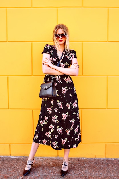 Pretty Blonde Woman in Floral Dress Posing by Yellow Wall – Free Download