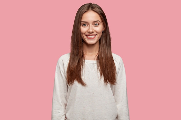 Pleasant Looking Cheerful Beautiful Brunette Posing Against the Pink Wall – Free Download