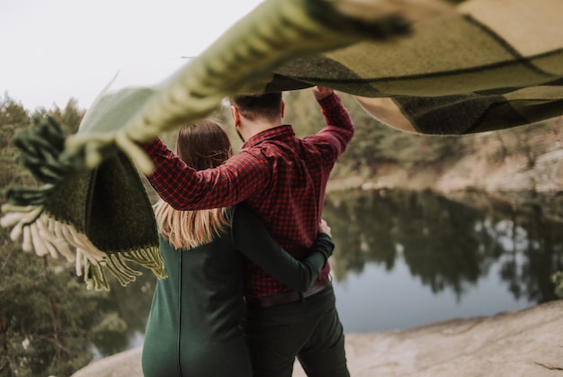 Loving Couple on a Scenic Lake Shore with Rug in the Wind – Free Stock Photo, Download Free