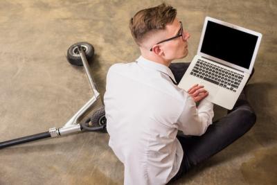 An Elevated View of a Young Man Sitting on the Floor with a Laptop – Free Stock Photo for Download