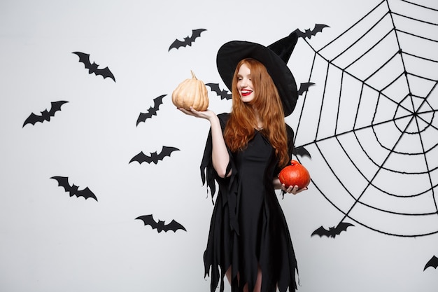 Portrait of a Beautiful Caucasian Witch Holding a Pumpkin for Halloween â Free to Download