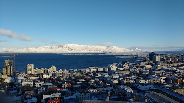 Aerial View of Reykjavik with Snow-Capped Mountains Against a Blue Sky – Free Stock Photo for Download