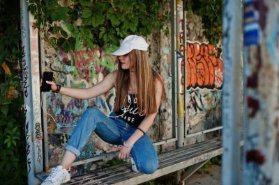 Casual Hipster Girl with Headphones Against Graffiti Wall – Free Download