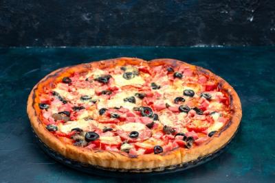 Baked Delicious Pizza with Olives, Sausages, and Cheese on a Blue Desk – Free Download