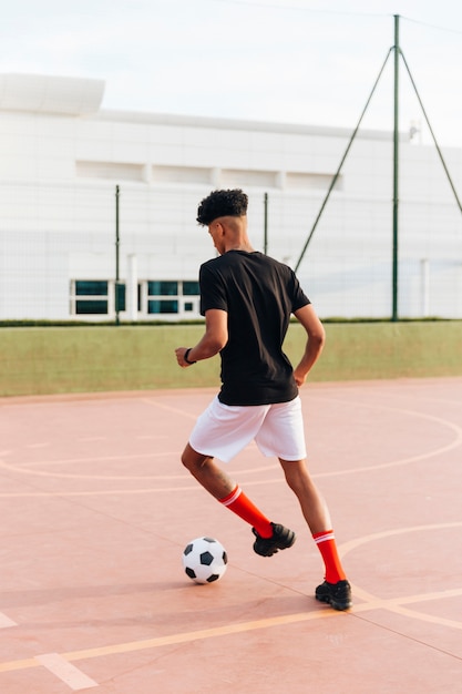 Black Sportsman Playing Football on the Sports Ground – Free Download