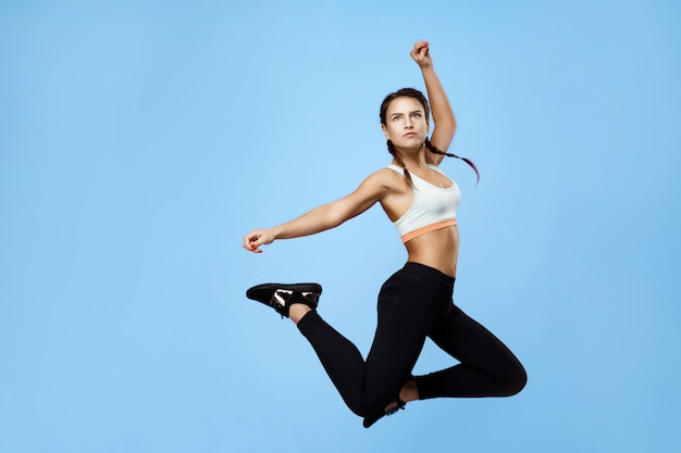 Excited Fitness Woman in Colorful Sportswear Jumping High – Free Download