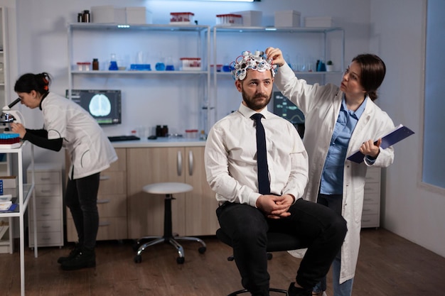 Neurologist Female Researcher Adjusting EEG Headset for Brain Activity Monitoring – Free Download