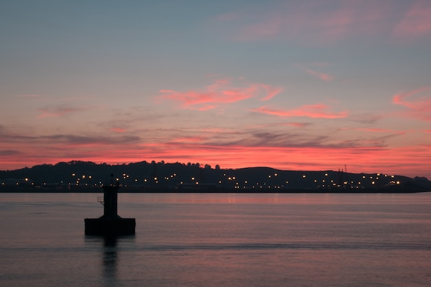 Stunning Pink Sunset Over a Lake with Captivating City Lights – Free Download