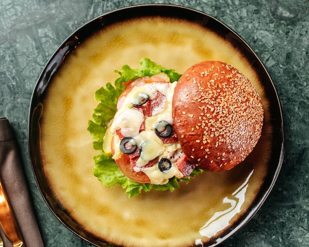 A Top View Burger with Olives, Cheese, and Vegetables in a Round Pan – Free to Download