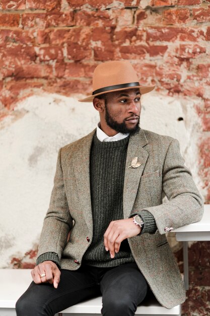 Handsome Man Posing Against a Brick Wall – Free Stock Photo for Download