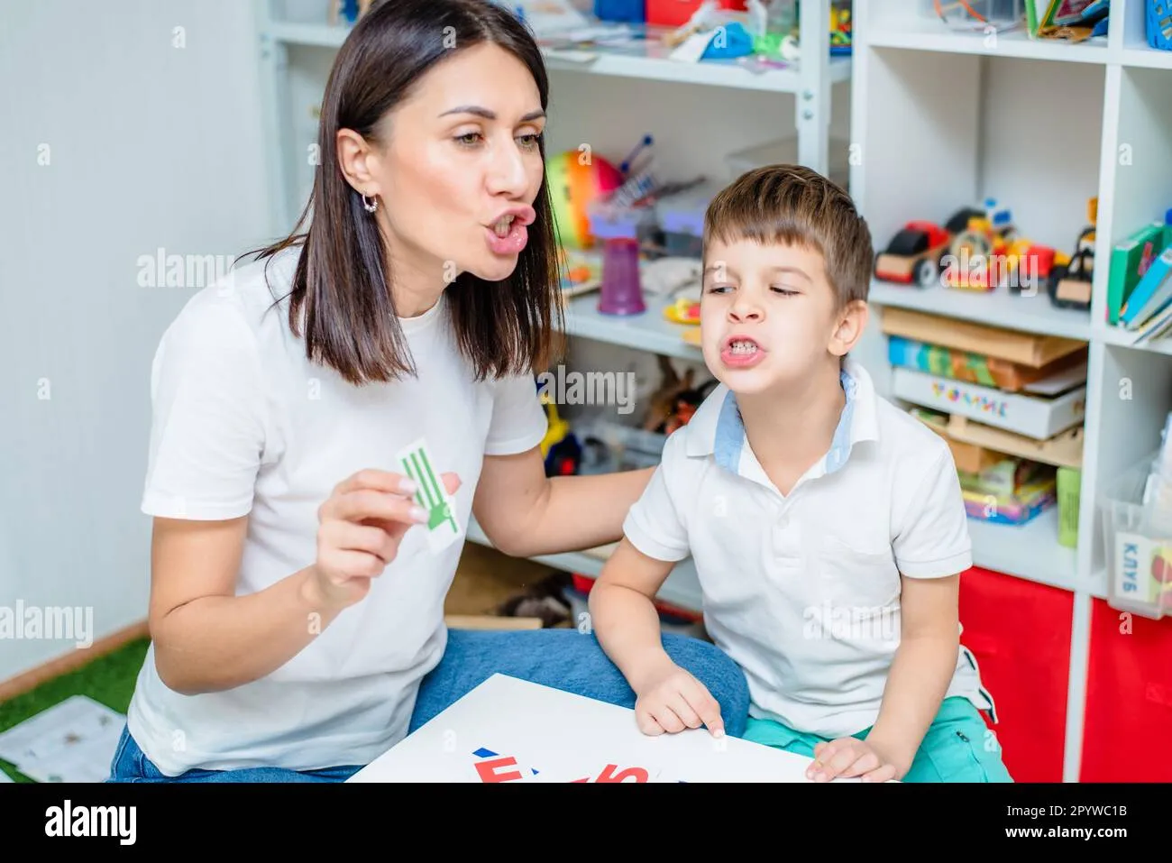 Cute woman speech therapist teaches child to pronounce words sounds and 