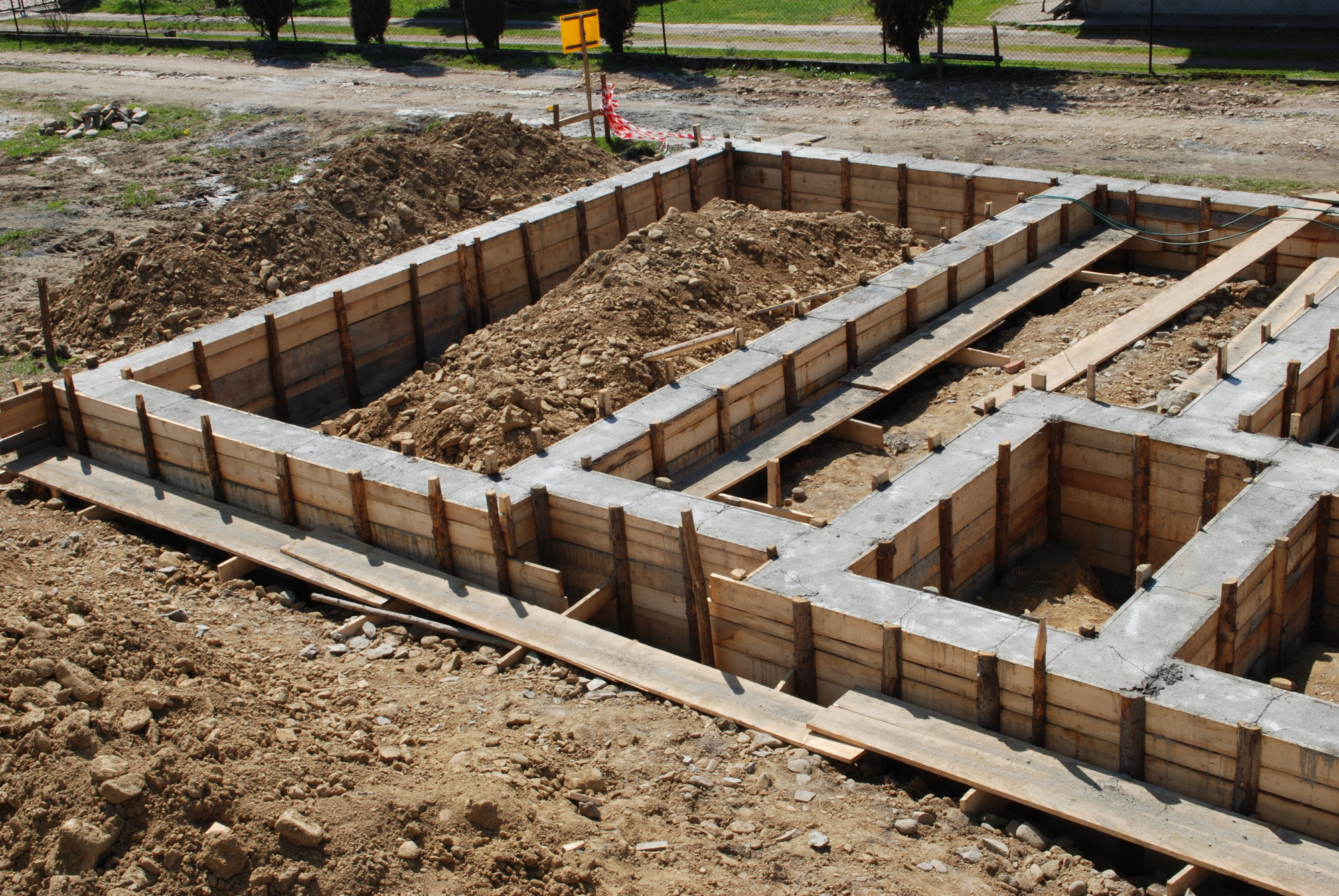 3 Common Types of Building Foundations  Brown Concrete and Backhoe 