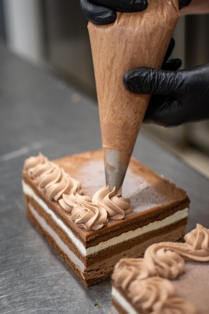 Premium Photo  Pastry chef decorating cake using a piping bag