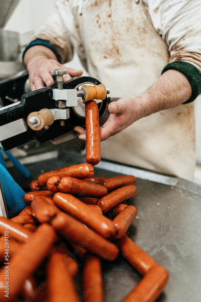 Experienced male worker makes and fills delicious hot dogs in fresh
